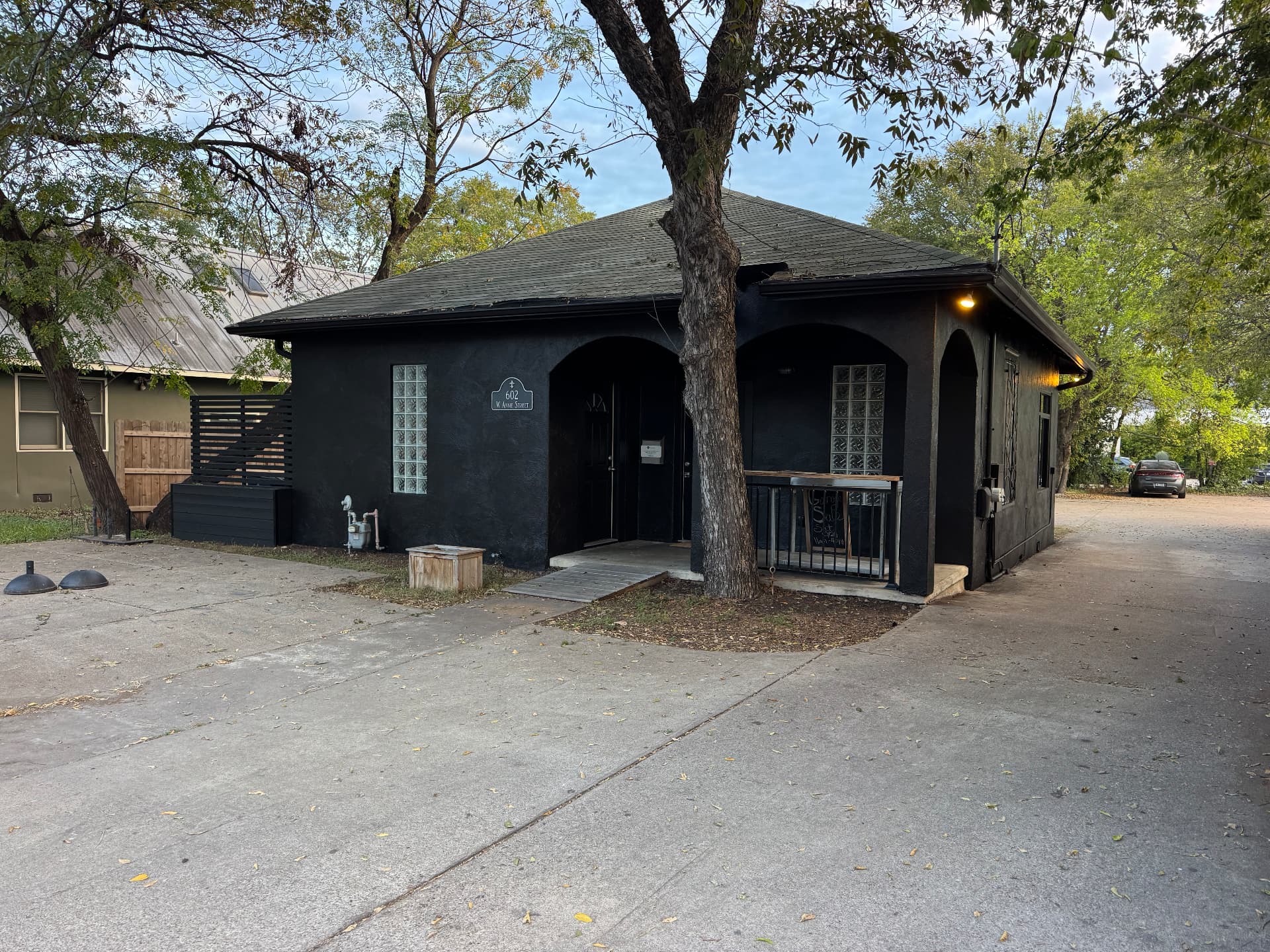 A South Austin storefront finished in dark paint at dusk after an MTL repaint.