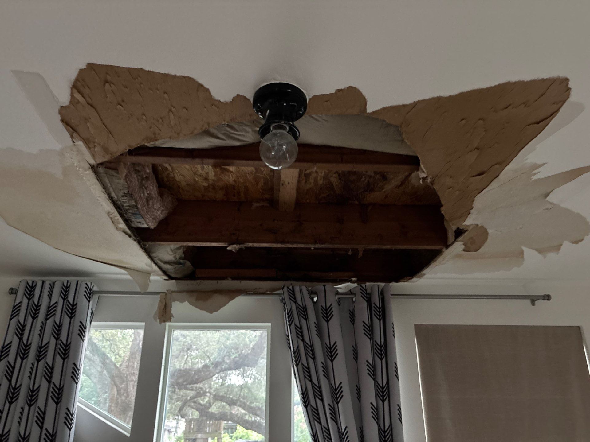 Ceiling opened to expose framing and roof leak damage