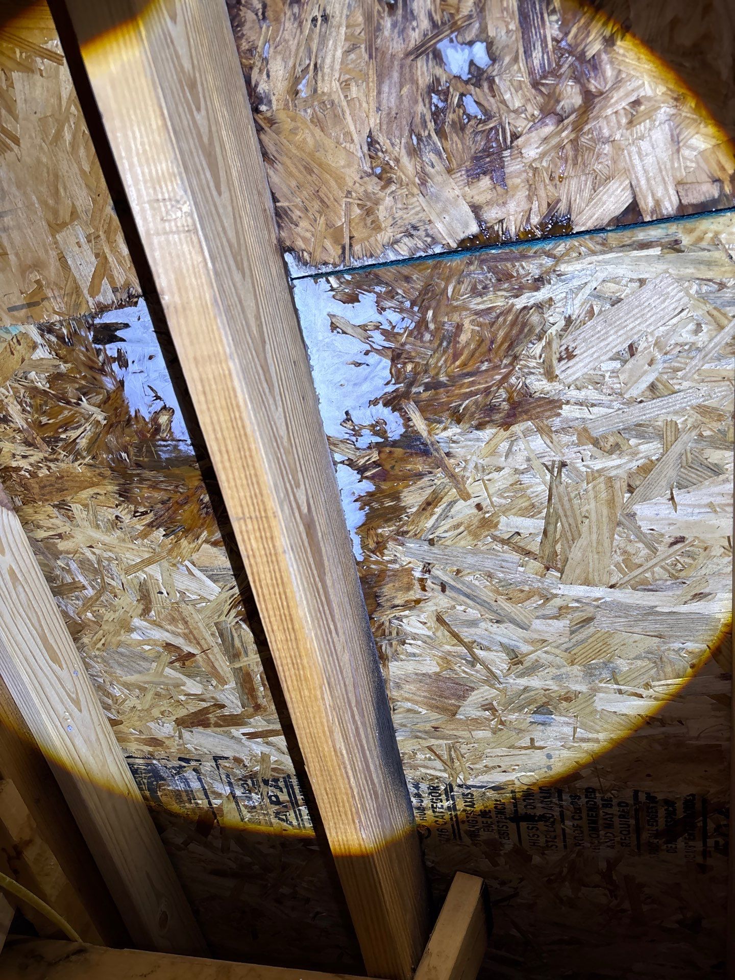 Moisture staining on the underside of roof decking viewed from an attic