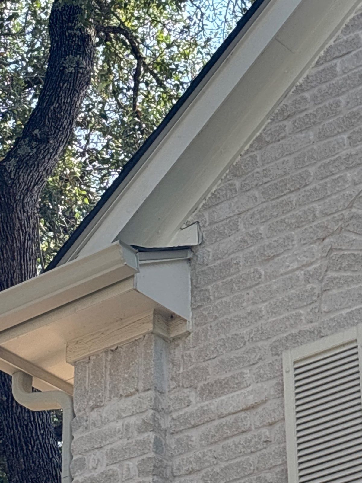 The same roof edge after repair, with new trim installed and painted to match.