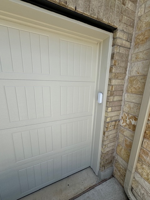 Finished right-side garage door trim next to stone masonry
