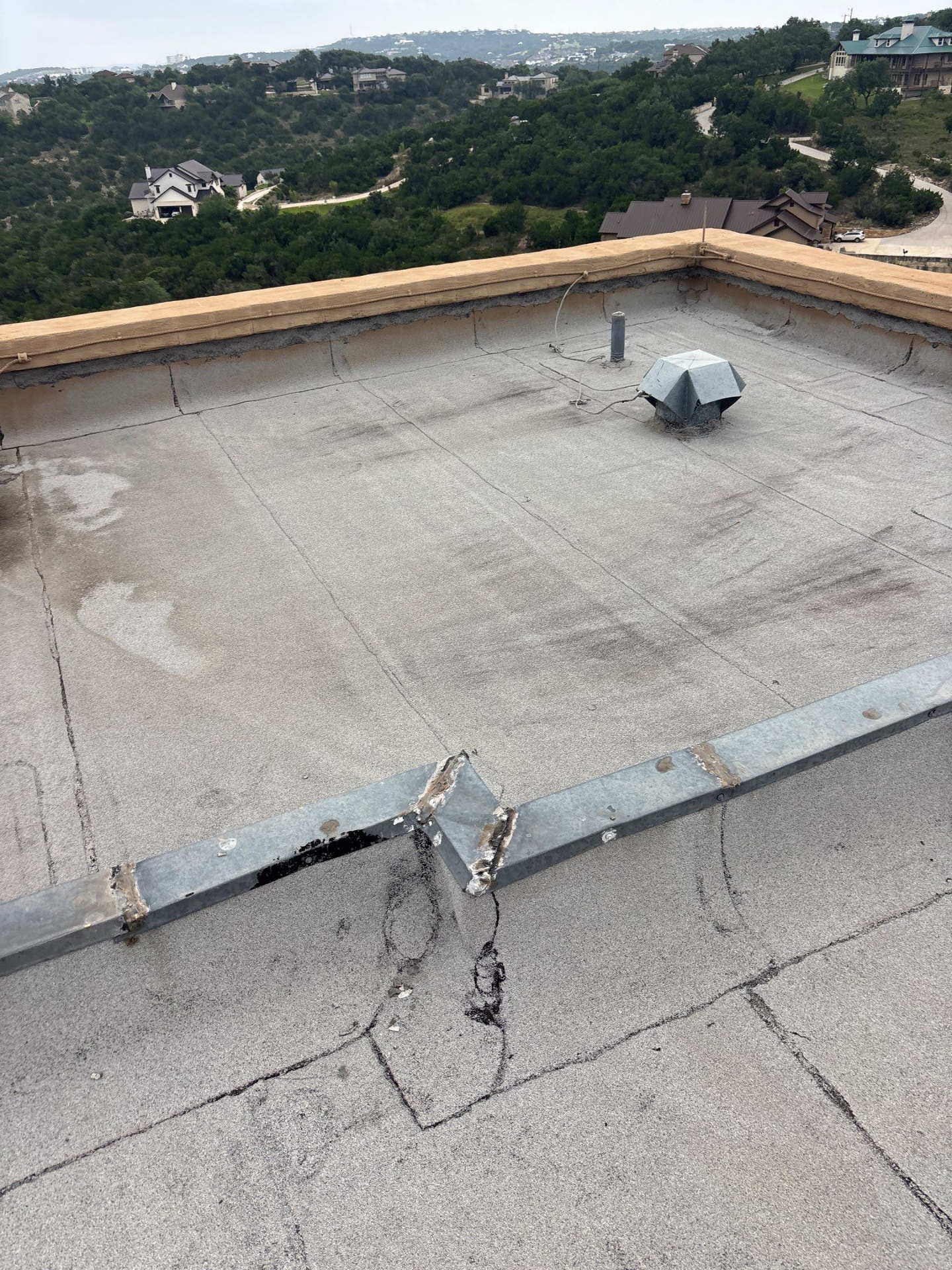 Modified bitumen low-slope roof with seams, penetrations and previous repairs